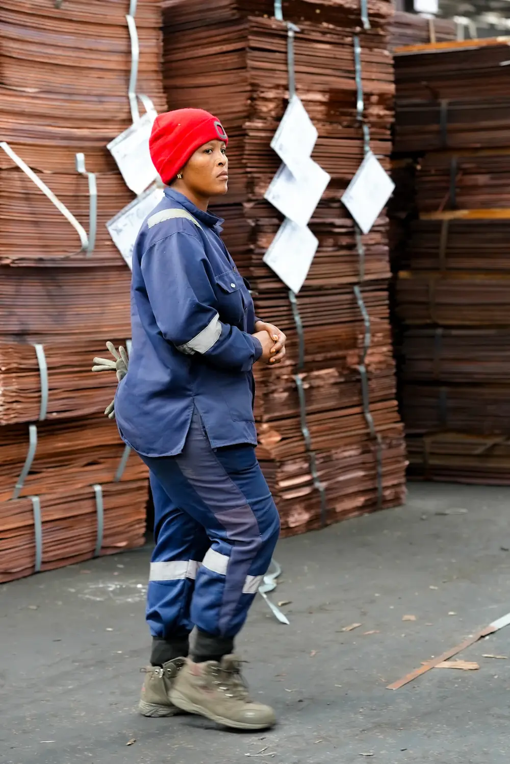 Warehouse supervisor standing in front of stacked copper sheets