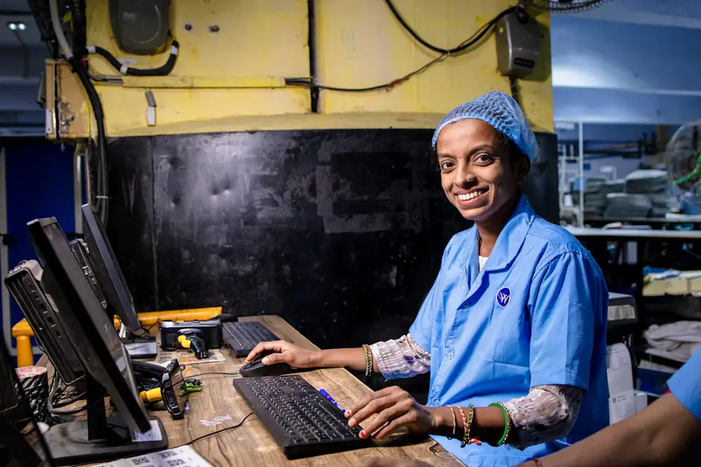 Textile worker smiling at her workstation